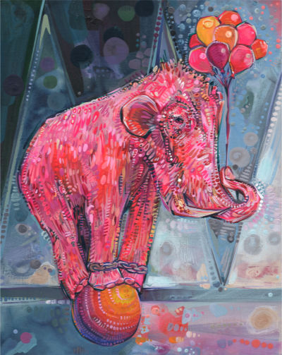 pink woolly mammoth balancing on a ball and holding helium-filled balloons