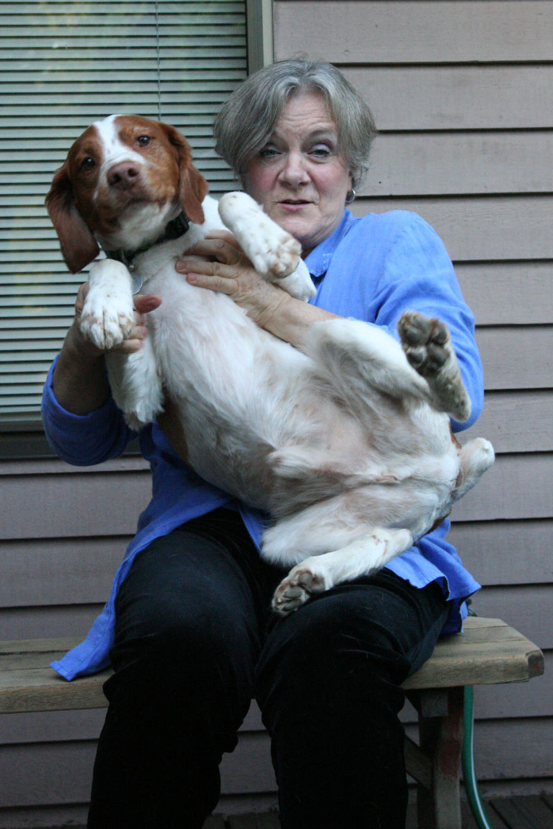 dog struggling to get out of a woman’s lap