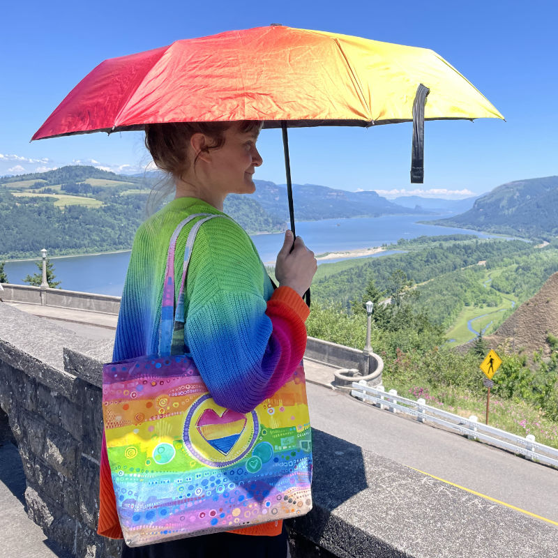 photo of a white person using a rainbow sunbrella