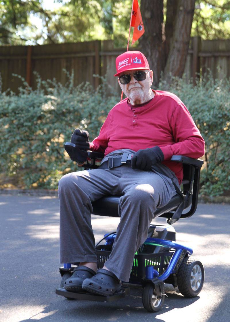 photo d’un vieil homme blanc dans un fauteuil roulant électrique